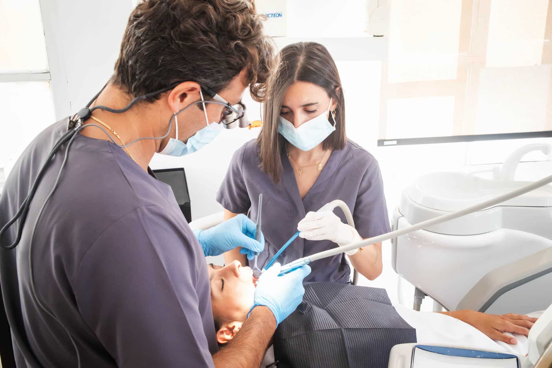 dentistas en consultorio revisando a un paciente